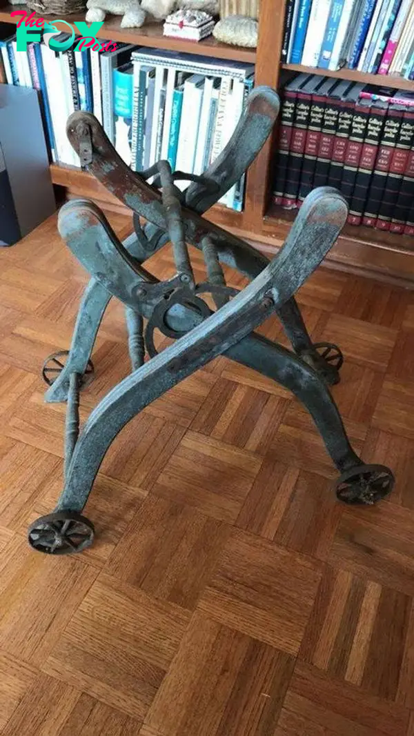 Rusted old metal base. Wood floor and books in the background.