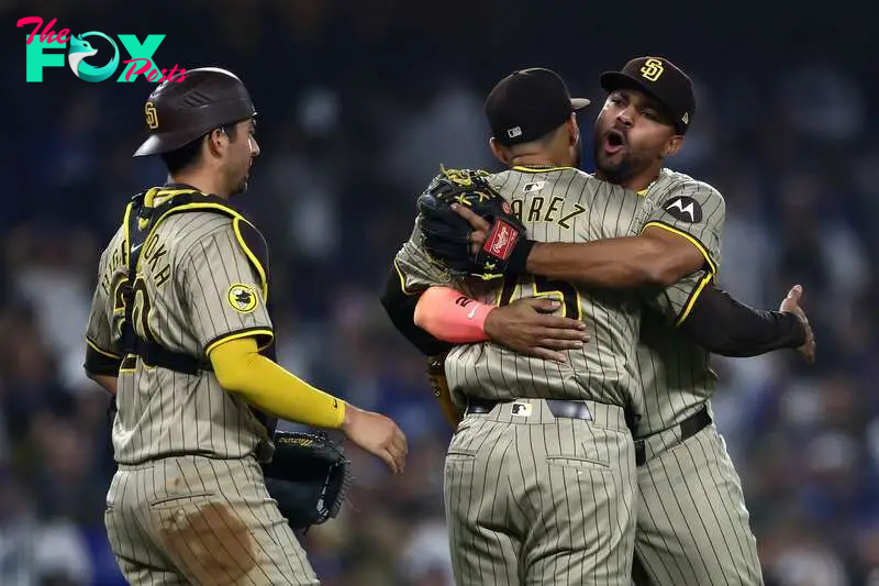 LOS ANGELES, CALIFORNIA - SEPTEMBER 24: Kyle Higashioka #20, Robert Suarez #75 and Xander Bogaerts #2 of the San Diego Padres celebrate after the 4-2 win against the Los Angeles Dodgers to clinch a playoff spot at Dodger Stadium on September 24, 2024 in Los Angeles, California.   Katelyn Mulcahy/Getty Images/AFP (Photo by Katelyn Mulcahy / GETTY IMAGES NORTH AMERICA / Getty Images via AFP)