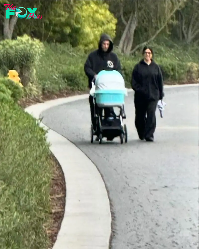 Kourtney and Travis walking baby Rocky in his pram