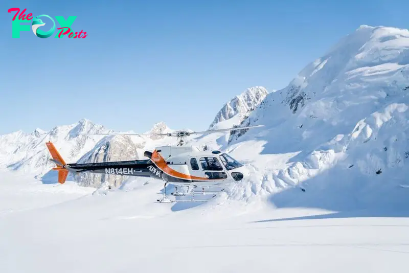 Helicopter flying over Alaskan mountain range