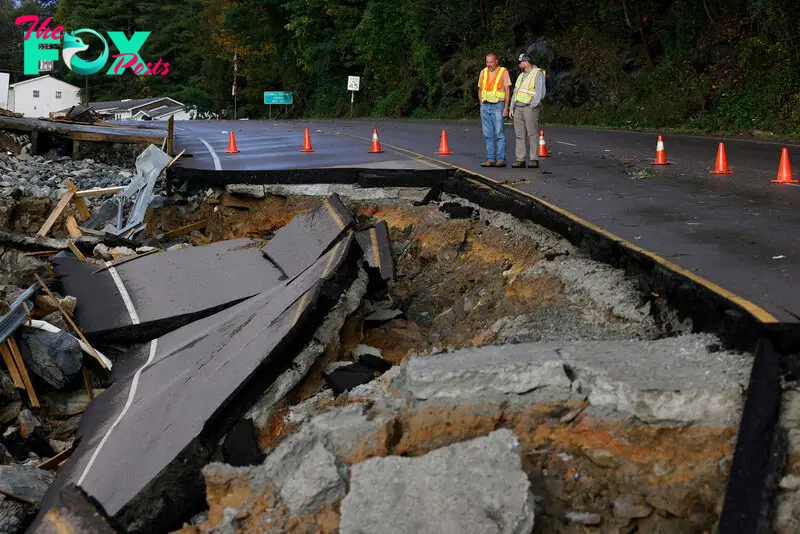 Workers survey large section of highway washed away by Tropical Storm Helene in Boone, North Carolina