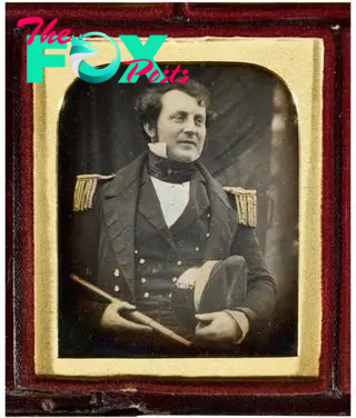 A black and white photo in a frame. It shows James Fitzjames in a Royal Navy uniform.