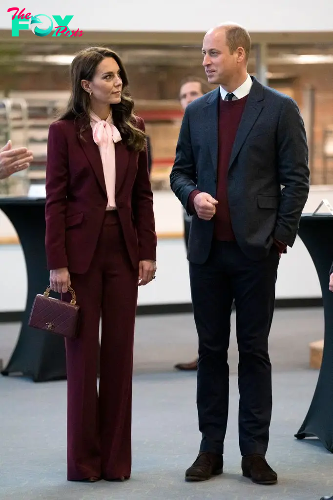 Kate in burgundy stylish suit beside william