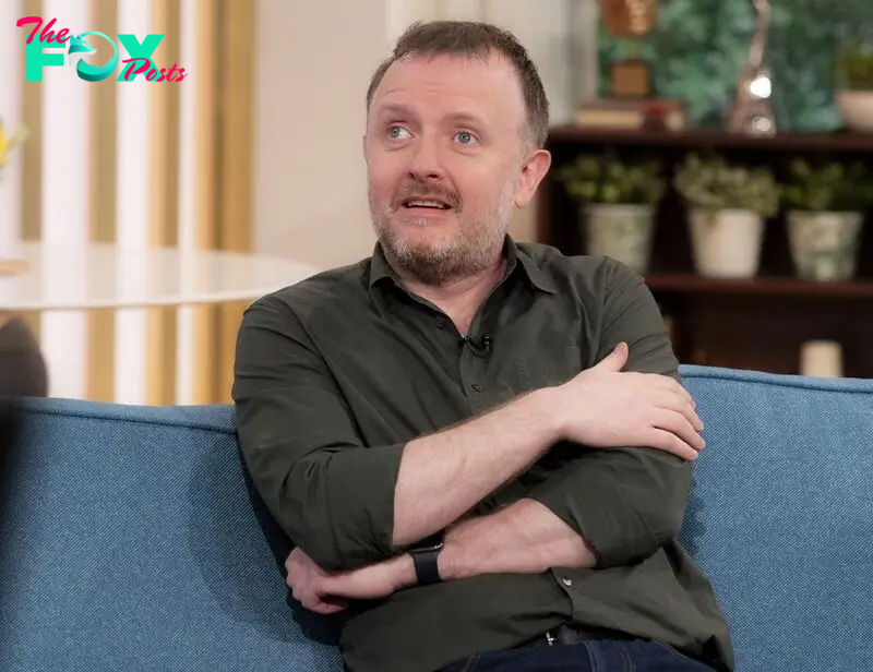 Chris McCausland on blue sofa in khaki shirt