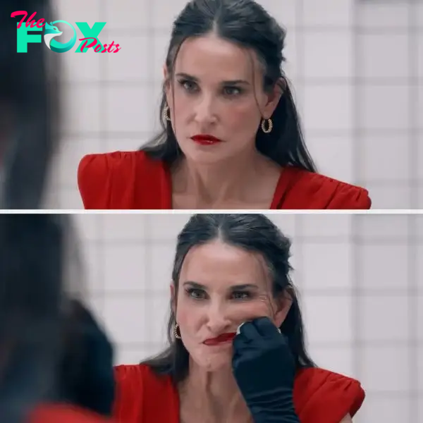 Demi Moore, wearing a chic red dress and gold hoop earrings, looks worried in a bathroom mirror in this scene from &quot;Brave New World.&quot;