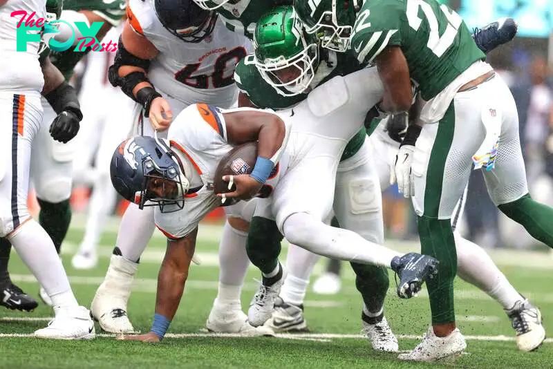 EAST RUTHERFORD, NEW JERSEY - SEPTEMBER 29: Tyler Badie (28) of the Denver Broncos is tackled by the New York Jets during the second quarter at MetLife Stadium on September 29, 2024 in East Rutherford, New Jersey.   Mike Stobe/Getty Images/AFP (Photo by Mike Stobe / GETTY IMAGES NORTH AMERICA / Getty Images via AFP)