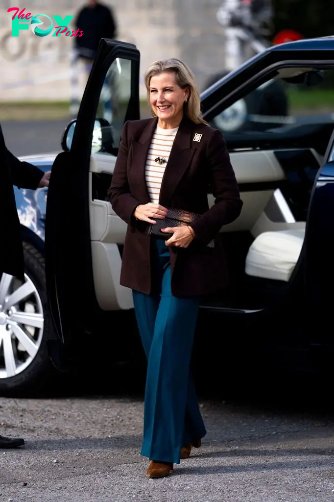 The Duchess of Edinburgh walking in blazer and teal trousers