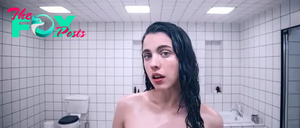 I don’t know who this person is. They are in a tiled bathroom, with slicked back wet hair, looking into the camera