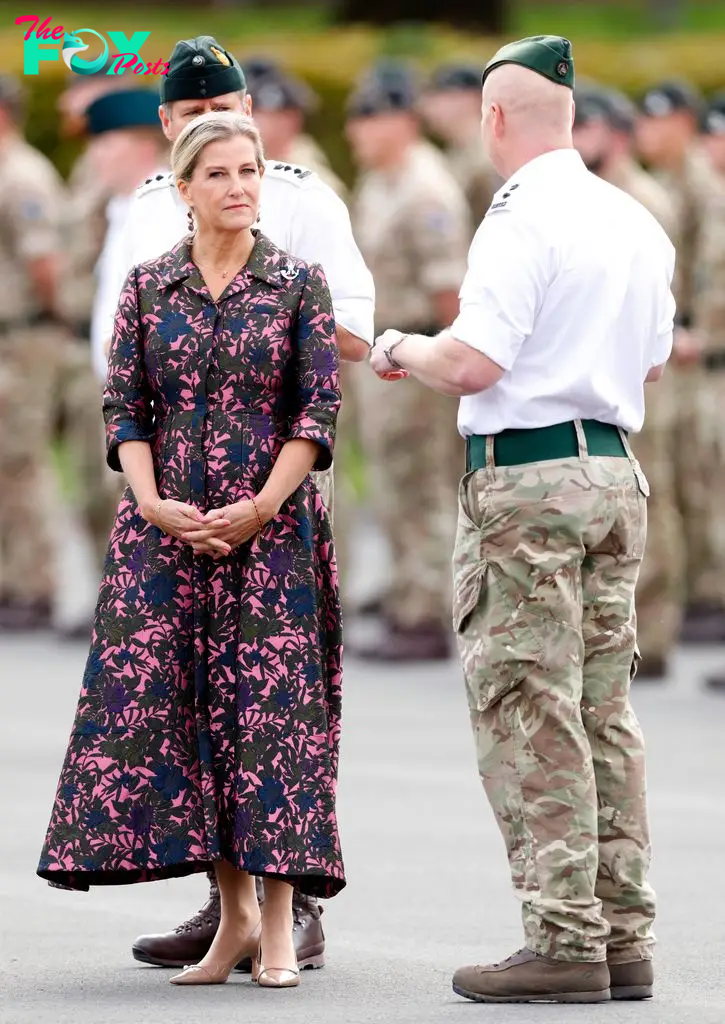 Sophie in floral dress with members of military