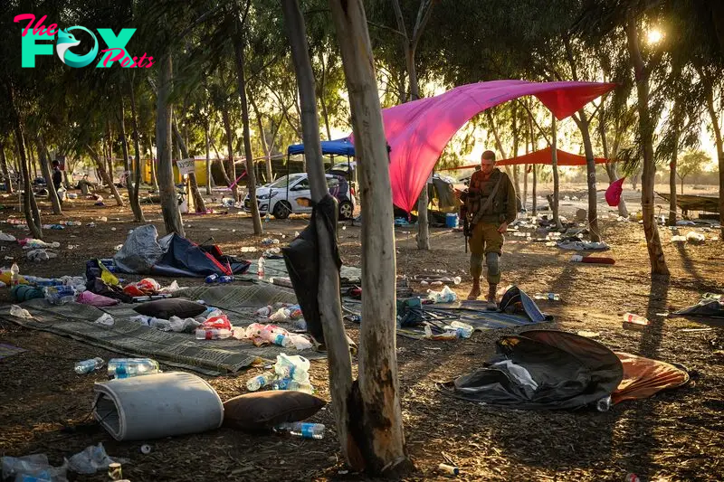 Members of the security forces search for identification and personal items at the Nova music festival site, in Kibbutz Re'im, Israel, on Oct. 12, 2023.