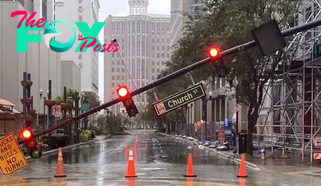 A snapped traffic signal pole blocks the street in the downtown business area after Hurricane Milton passed through