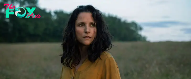 A close-up of a woman in a yellow shirt with dark long hair standing in a field in Tuesday.