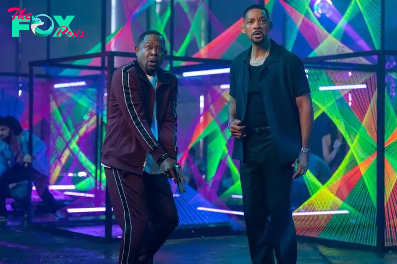 Two men standing next to one another in a nightclub, looking bewildered in Bad Boys: Ride or Die.