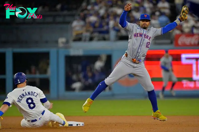 Oct 13, 2024; Los Angeles, California, USA; Los Angeles Dodgers third base Enrique Hernández (8) slides safely into second bae against New York Mets shortstop Francisco Lindor (12) in the eighth inning during game one of the NLCS for the 2024 MLB Playoffs at Dodger Stadium. Mandatory Credit: Jayne Kamin-Oncea-Imagn Images