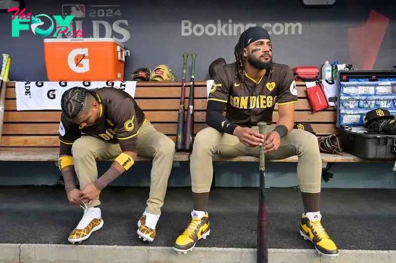 Oct 11, 2024; Los Angeles, California, USA; San Diego Padres first baseman Luis Arraez (4) and outfielder Fernando Tatis Jr. (23) look on in the dugout before game five against the Los Angeles Dodgers in the NLDS for the 2024 MLB Playoffs at Dodger Stadium. Mandatory Credit: Jayne Kamin-Oncea-Imagn Images