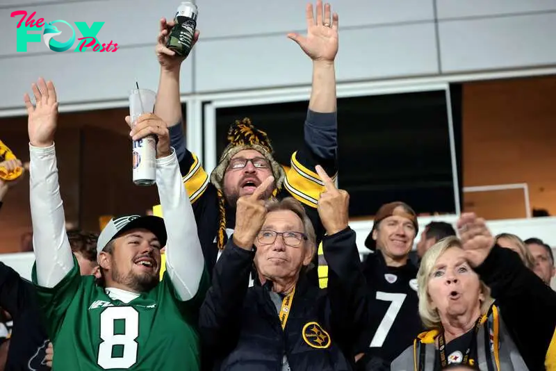 SENSITIVE MATERIAL. THIS IMAGE MAY OFFEND OR DISTURB   PITTSBURGH, PENNSYLVANIA - OCTOBER 20: Football fans react to members of the media as they document Republican presidential nominee, former U.S. President Donald Trump as he attends the Pittsburgh Steelers game against the New York Jets at Acrisure Stadium on October 20, 2024 in Pittsburgh, Pennsylvania. Win McNamee/Pool via REUTERS