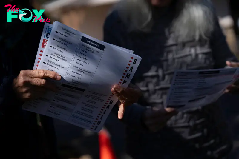 A woman holds a sample ballot on Oct. 18, the second day of early voting in North Carolina