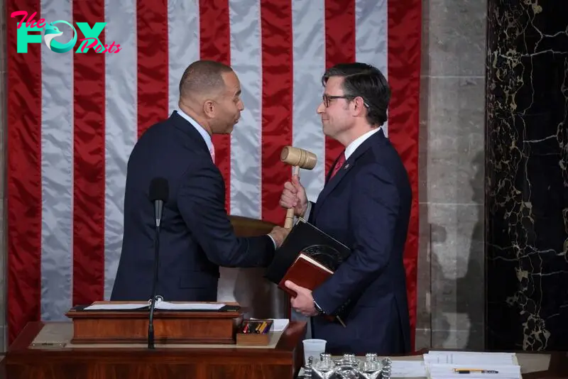 U.S. House Minority Leader Hakeem Jeffries (L) hands newly elected House Speaker Mike Johnson the gavel at the U.S. Capitol in Washington, D.C., on Oct. 25, 2023.