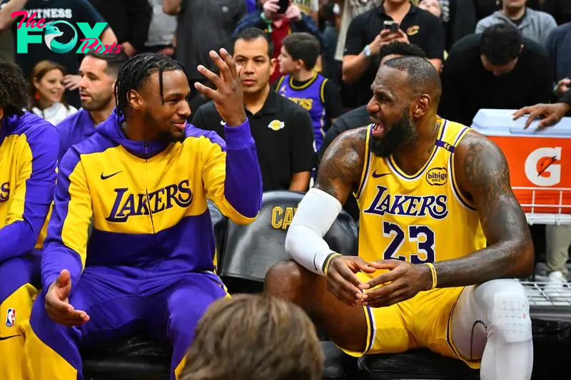 Bronny James talks with his father, LeBron James, on the Lakers bench.