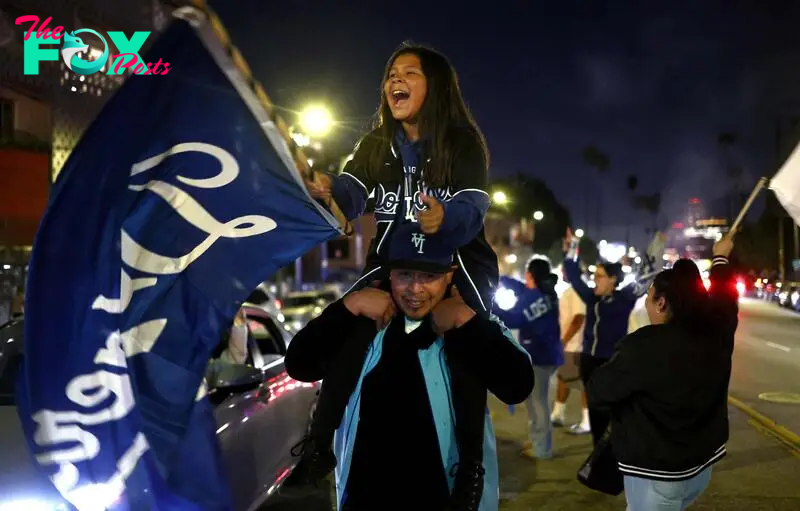 LOS ANGELES, CALIFORNIA - OCTOBER 30: Dodgers fans celebrate on Sunset Boulevard after the Los Angeles Dodgers defeated the New York Yankees in Game 5 to win the World Series against the New York Yankees on October 30, 2024 in Los Angeles, California. The Dodgers plan to hold a victory parade on Friday.   Mario Tama/Getty Images/AFP (Photo by MARIO TAMA / GETTY IMAGES NORTH AMERICA / Getty Images via AFP)