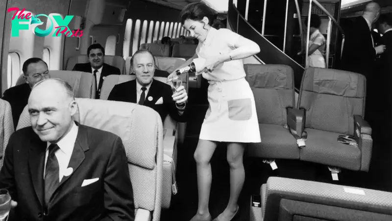 golden age of flying - A Pan Am flight attendant serves champagne in the first class cabin of a Boeing 747 jet