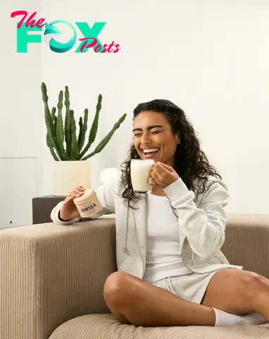 Girl smiling drinking a DIRTEA Lion's Mane tea holding a DIRTEA Lion's Mane tin