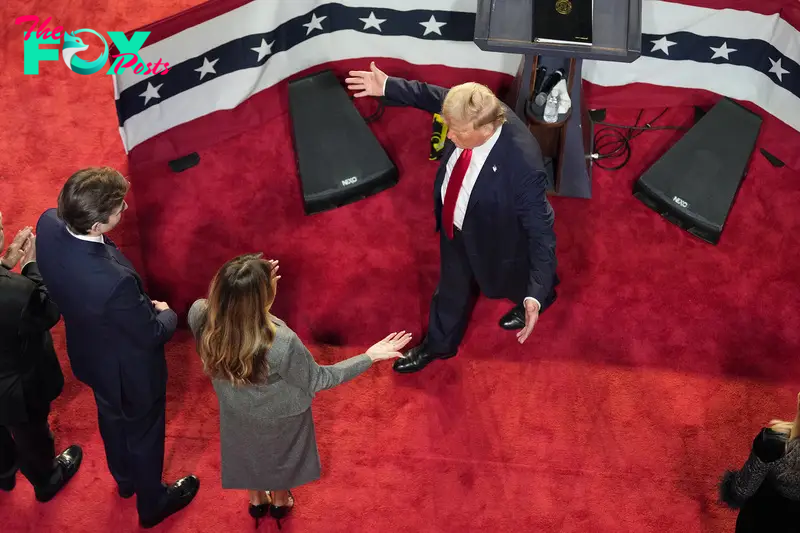 Republican presidential nominee former President Donald Trump walks over to hug former first lady Melania Trump as their son Barron Trump, left, after delivering remarks to supporters at an election night watch party in West Palm Beach, Fla., Nov. 6, 2024.