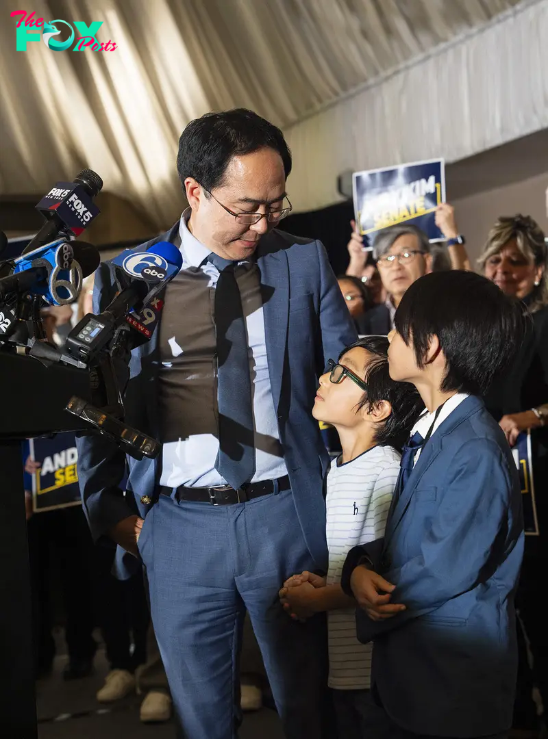 Rep. Andy Kim looks as his sons August Lai, right, and Austin Lai while speaking with reporters after he was projected the winner of his Senate race in Cherry Hill, N.J., on Nov. 5, 2024.