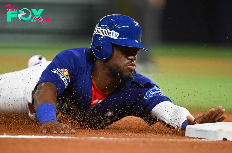 Venezuela's outfielder #20 Odubel Herrera dives to third base during the Caribbean Series baseball championship game between the Dominican Republic and Venezuela at LoanDepot Park in Miami, Florida, on February 9, 2024. (Photo by Chandan Khanna / AFP)