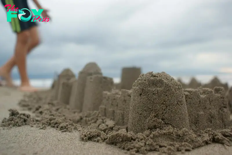 A kid standing near a sand castle | Source: Pexels