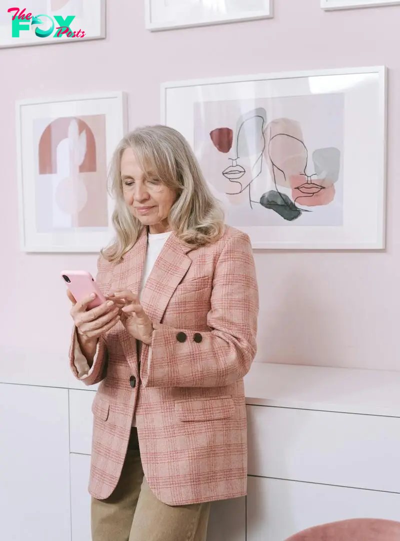 A satisfied-looking woman holding a phone | Source: Pexels