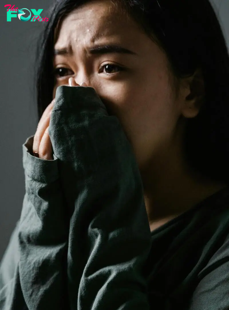 A distressed woman covering her nose and mouth | Source: Pexels