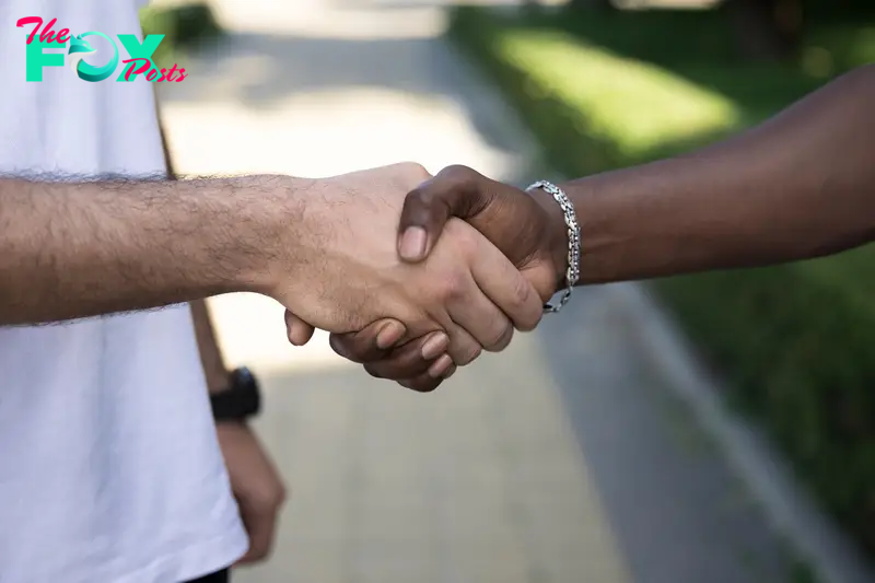 Two men shaking hands outside | Source: Freepik