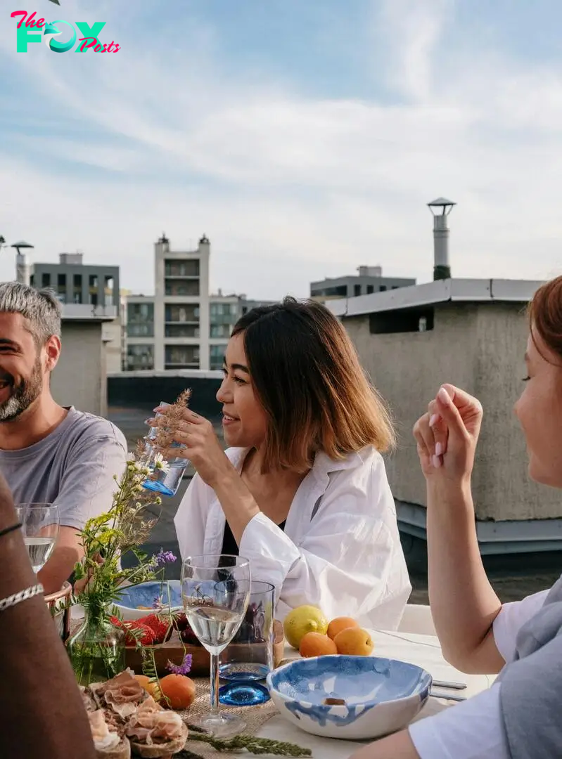 People talking and laughing at a table full of food | Source: Pexels