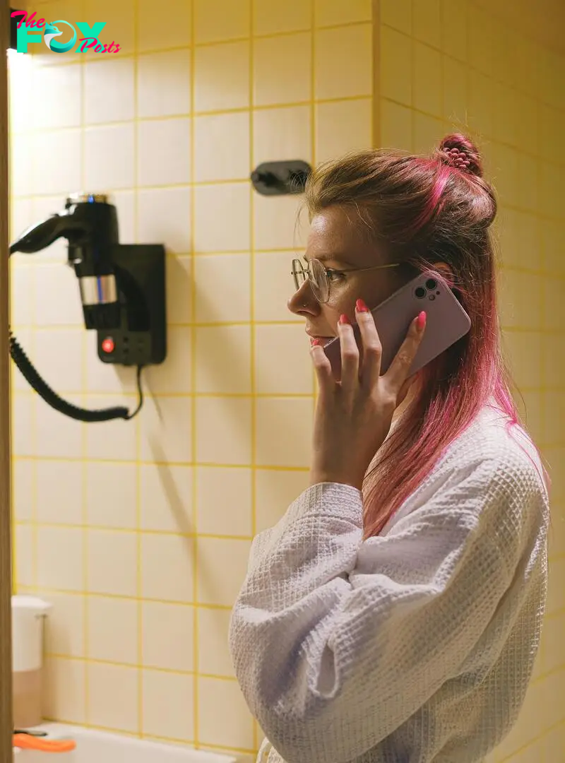 A woman talking on a phone in a bathroom | Source: Pexels