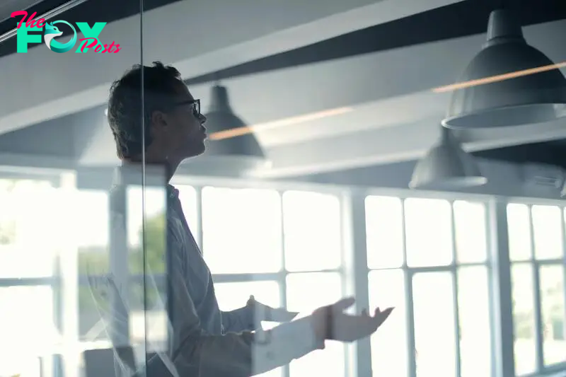 Man talking behind a glass panel | Source: Pexels