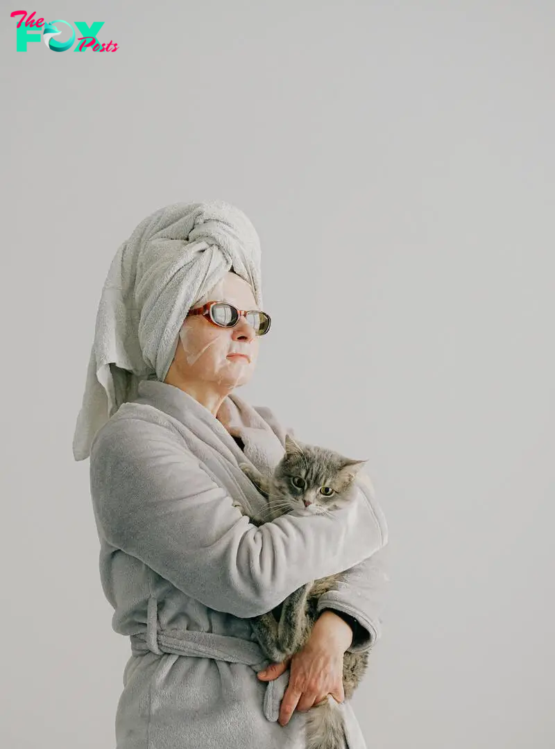 An arrogant woman dressed in a gown, and sunglasses while holding a cat | Source: Pexels