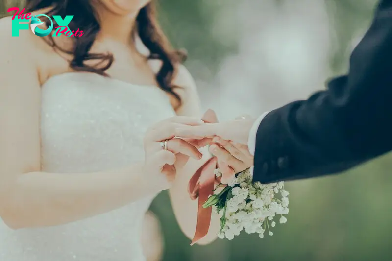 A bride putting on the groom's wedding ring | Source: Unsplash