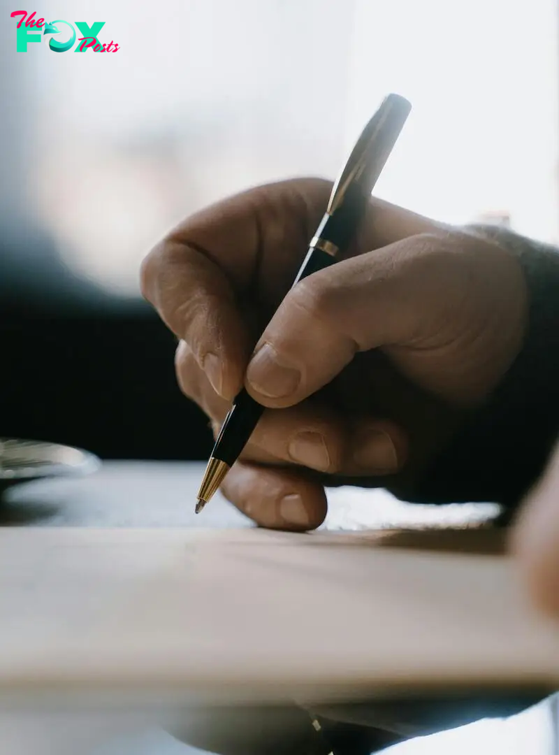 A man writing on a piece of paper | Source: Pexels