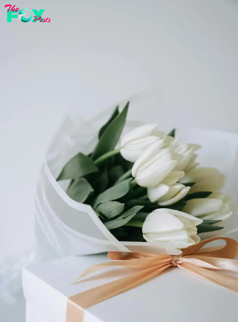 A bouquet of white tulips and a giftbox | Source: Pexels