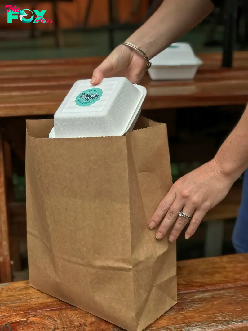 A person packing takeout into a brown bag | Source: Unsplash