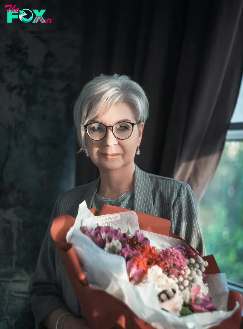 A smiling woman holding a bouquet of flowers | Source: Pexels