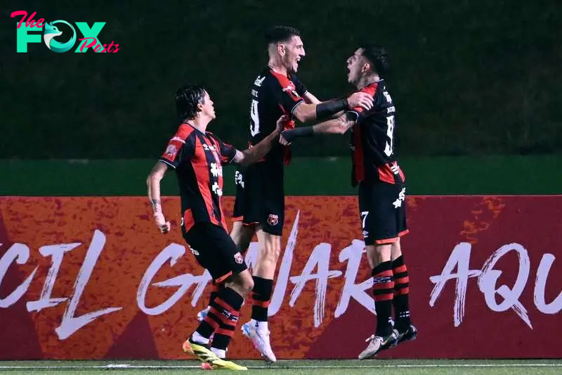 Alajuelense's Alberto Toril (C) celebrates with teammates