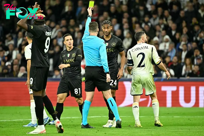 Napoli's Sweden�s midfielder #24 Jens Cajuste is presented a yellow card by French referee Francois Letexier during the UEFA Champions League first round group C football match between Real Madrid CF and SSC Naples at the Santiago Bernabeu stadium in Madrid on November 29, 2023. (Photo by JAVIER SORIANO / AFP)