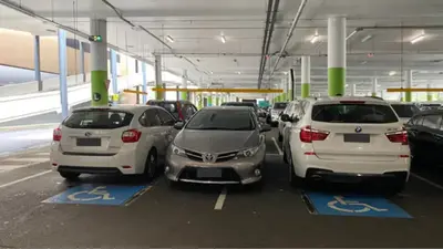 Sydney driver slammed online for parking in between two disabled car parks at a shopping centre