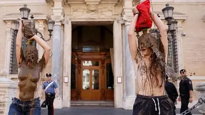 Climate activists smear themselves with mud to evoke flooding in Italy