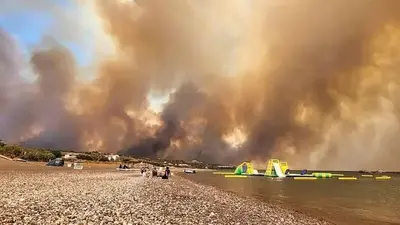 A wildfire is raging out of control on the Greek island of Rhodes, forcing tourist evacuations