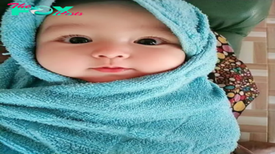 Mesmerizing: The adorable moment of an adorable newborn being wrapped in a towel leaves parents spellbound