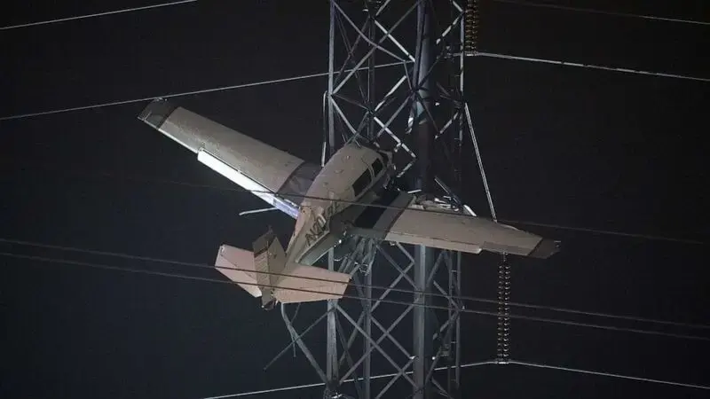 2 trapped in small plane after it strikes high-tension power lines
