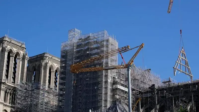 Crane at fire-ravaged Notre Dame in Paris hoists giant wood trusses to the cathedral's roof